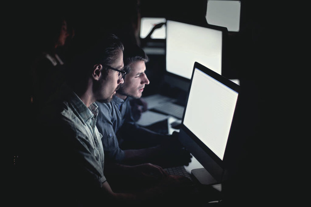 business team works on computers at night. - Zdjęcie, obraz