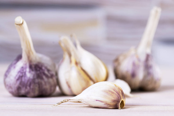Fresh ripe garlic cloves and bulbs on a wooden table. Healthy organic food, vitamins, organic food, natural background. - 写真・画像