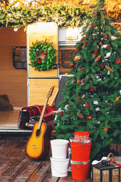 Decorated Christmas tree near motorhome outdoors - Foto, Imagen
