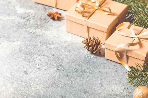 Świąteczne tło. Boże Narodzenie kompozycja z gałązek jodły, prezenty, słodycze, cynamon na jasnym tle betonu - Zdjęcie, obraz