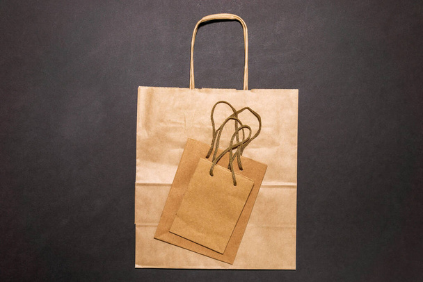 Öko-Papiertüte mit der Aufschrift Zero Waste auf schwarzem Hintergrund, flache Position, Online-Shopping-Konzept von oben - Foto, Bild