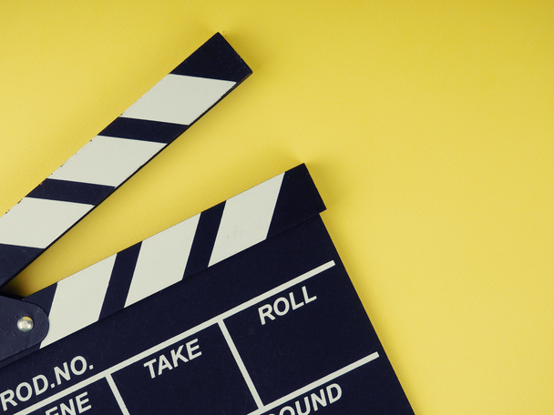 the concept of the film industry, a minimalistic composition on a yellow background with glasses and clapperboard. movies and cinema. - Foto, Imagen