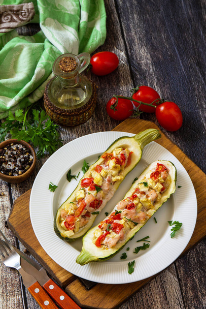 Gesunde Ernährung. Gebackene Zucchini gefüllt mit Fleisch und Tomaten auf einem rustikalen Holztisch. Kopierraum. - Foto, Bild