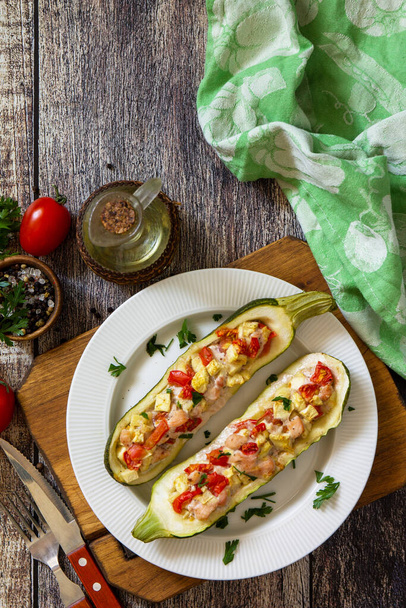 Gesunde Ernährung. Gebackene Zucchini gefüllt mit Fleisch und Tomaten auf einem rustikalen Holztisch. Von oben betrachtet lag flach. Freier Platz für Ihren Text. - Foto, Bild