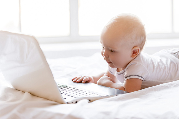 Baby holding hands on laptop keyboard - Foto, afbeelding