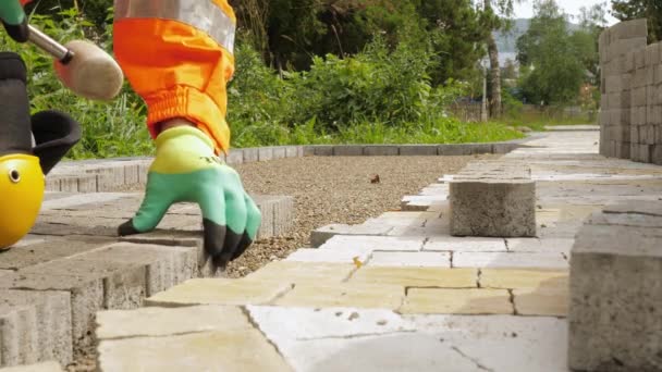 Construction worker makes new sidewalk pavement with stone bricks - Footage, Video