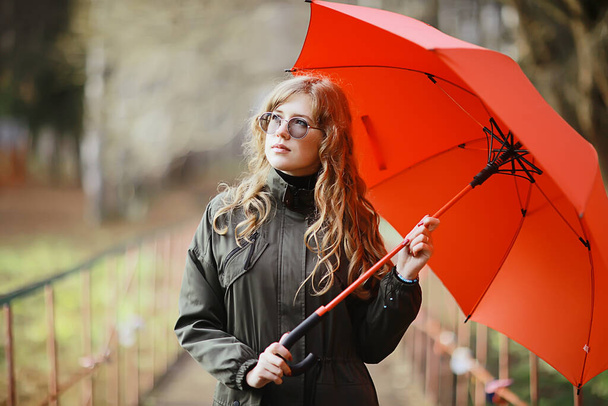 seasonal autumn portrait, sad girl with umbrella, november seasonal virus immunity on a walk - Foto, imagen