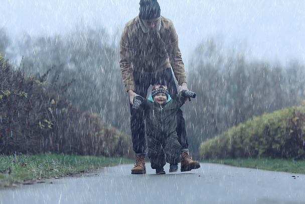 first step kid learns to walk, walk child and father in autumn in the park, winter style november - 写真・画像