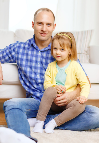 Smiling father and daughter sitting on the floor - Фото, изображение