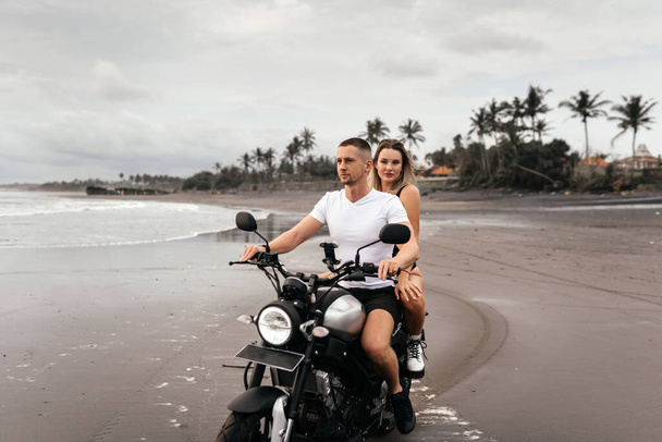 Young couple riding motorcycle on the beach - Fotoğraf, Görsel