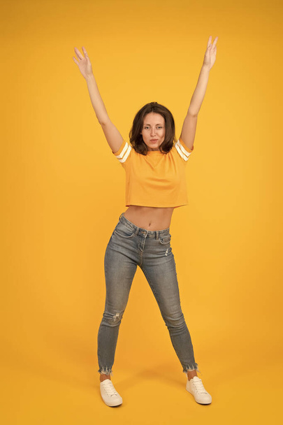 Hands up. Sexy woman yellow background. Pretty woman in casual style. Sensual woman with beauty look. Sexi woman with long brunette hair. Fashion and style. Beauty salon. Womens clothing store - Fotoğraf, Görsel