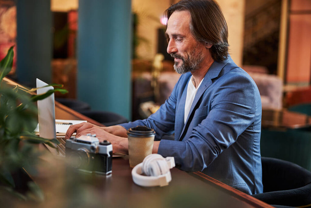 Contentado cavalheiro usando seu laptop em um lounge do hotel - Foto, Imagem