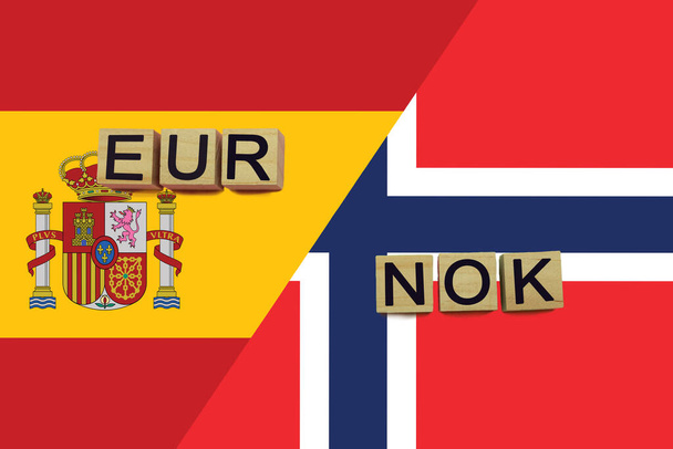 Коды валют Испании и Норвегии на фоне национальных флагов. Международная концепция денежных переводов - Фото, изображение
