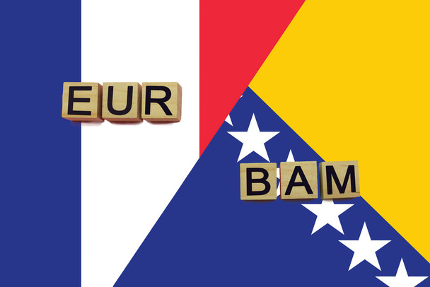 Francia y Bosnia códigos de monedas en banderas nacionales de fondo. Concepto internacional de transferencia de dinero - Foto, imagen