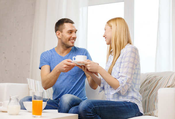 Man giving his girlfriend or wife cup of coffee - 写真・画像