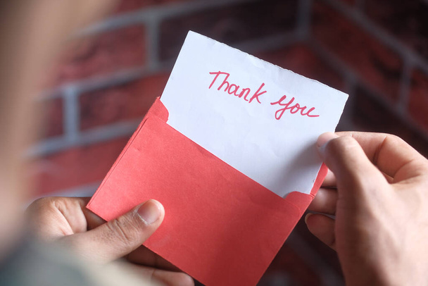 primo piano della mano dell'uomo che legge una lettera di ringraziamento  - Foto, immagini
