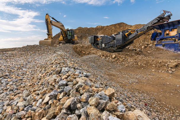 Escavadeira e máquina para pulverizar pedra em uma pedreira - Foto, Imagem
