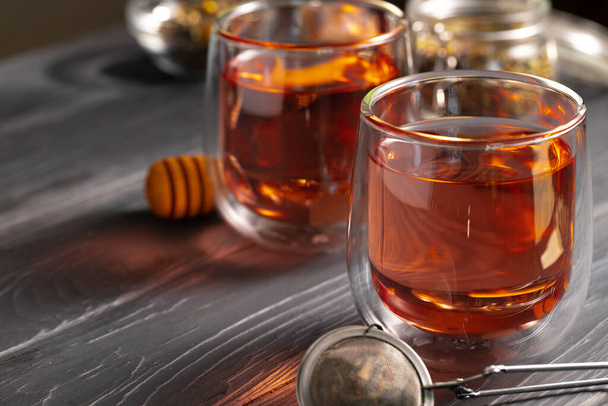 Glass teapot and glass cups of fruit tea on wooden background - Fotoğraf, Görsel