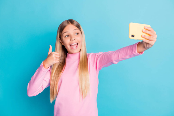 Photo portrait of pretty female preteen taking selfie showing thumb-up gesture like isolated on bright teal color background - 写真・画像