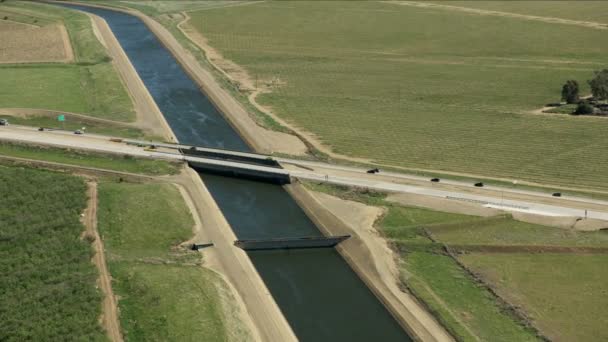 Aerial view aqueduct natural growth crops fields California - Filmati, video