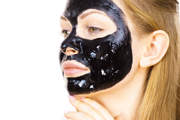 Young woman with cosmetic on face, carbo detox black peel off mask. Spa treatment. Skincare. - Zdjęcie, obraz