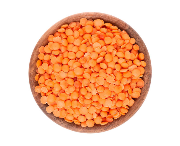 Red lentils in wooden bowl isolated on white background. Top view - Photo, Image