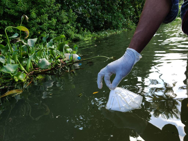 After effect of COVID,Collection of N 95 face mask collecting from the river,water pollution concept. Selective focus. - Photo, Image