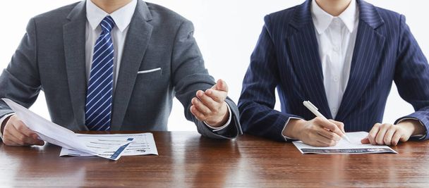 Two businessmen in elegant suits at a business meeting discussing documents in the office - Foto, imagen