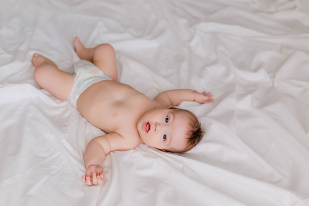 little boy baby lying on white sheets - Фото, изображение