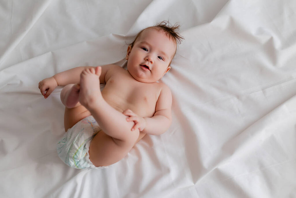 bebé acostado en la cama con los pies en alto - Foto, imagen