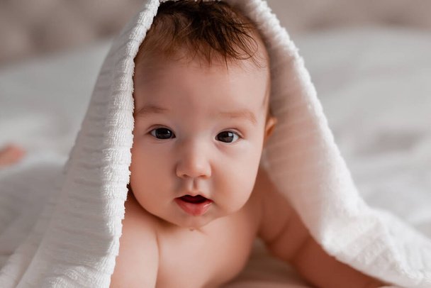 close up portrait of baby with towel on head - Foto, Bild