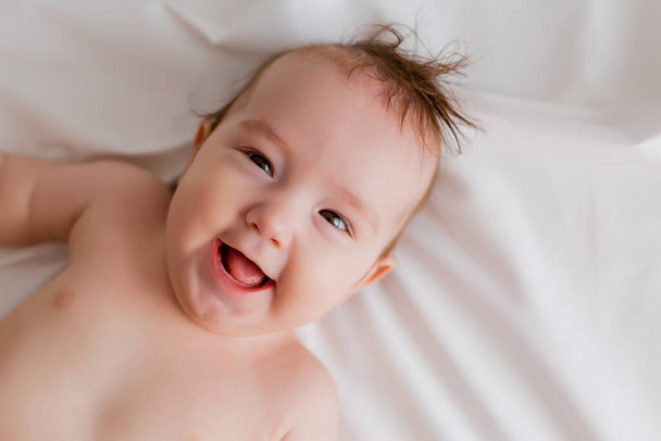 Yatakta uzanmış şirin bir bebeğin portresi. - Fotoğraf, Görsel