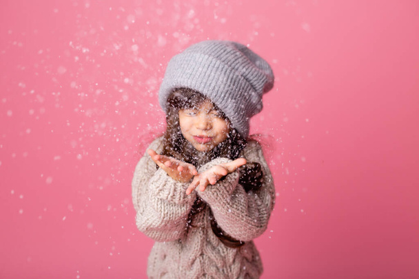 holčička v zimním oblečení pózuje s falešným sněhem  - Fotografie, Obrázek