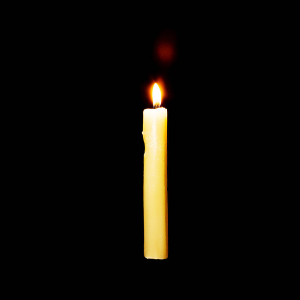 Горящая свеча висит в воздухе на черном фоне - Фото, изображение