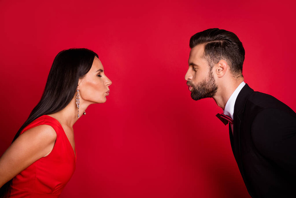 Photo of charming lady neat guy closing distance kiss lips closed eyes isolated on red color background - Фото, зображення