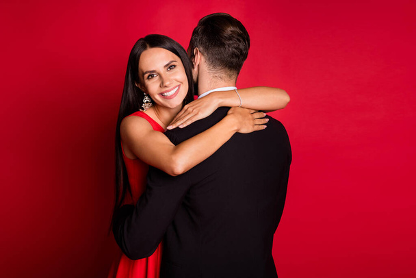 Photo of optimistic couple dance hug wear suit dress isolated on red color background - Φωτογραφία, εικόνα