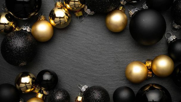 İyi tatiller. Siyah mücevherler, Noel süslemelerinde altın toplar. Tebrik kartı için koyu dokulu arka plan. Düz konum, üst görünüm, kopyalama alanı - Fotoğraf, Görsel