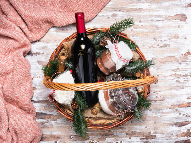 Різдвяний подарунковий кошик з пляшкою червоного вина та печивом
 - Фото, зображення
