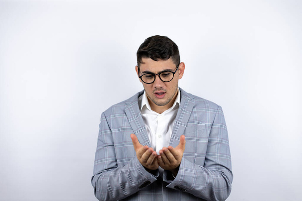 Business young man wearing a casual shirt over white background Smiling with hands palms together receiving or giving gesture. Hold and protection - Photo, Image