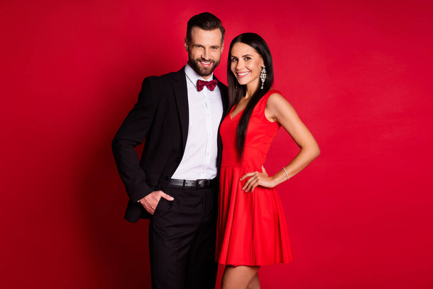 Photo of nice optimistic couple hug wear suit dress isolated on red color background - Fotografie, Obrázek
