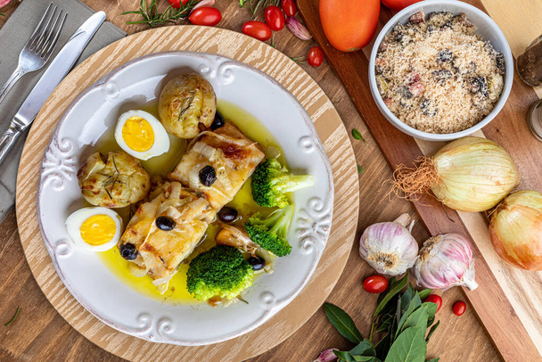 オリーブオイルで焼いたコードロース,ジャガイモと,ブロッコリー,ゆで卵と黒オリーブ.ポルトガル料理の代表格。最上階だ。テキストのスペース. - 写真・画像