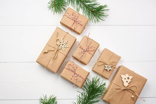 Christmas gift boxes with pine tree branches and decorations on white wooden background - Foto, Imagen
