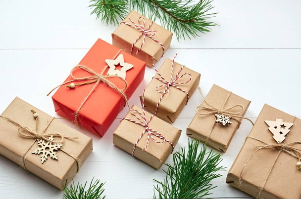 Christmas gift boxes with pine tree branches and decorations on white wooden background - Фото, изображение
