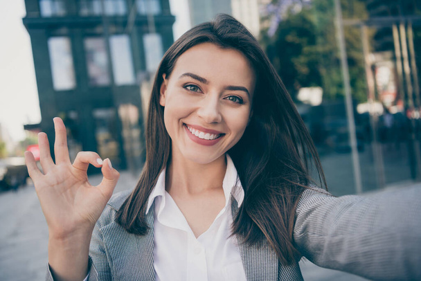 Photo of optimistic pretty businesswoman wear formalwear jacket take selfie make okay sign outside in outdoors - Foto, Imagem