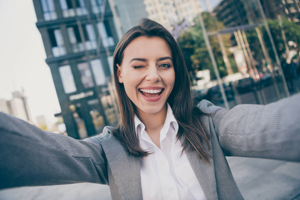 Photo of happy cheerful attractive young businesswoman take selfie wink eye outside in outdoors center - Photo, Image