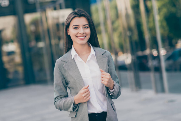 Photo of positive joyful young businesswoman wear hold formalwear jacket outdoors in city downtown - Fotoğraf, Görsel