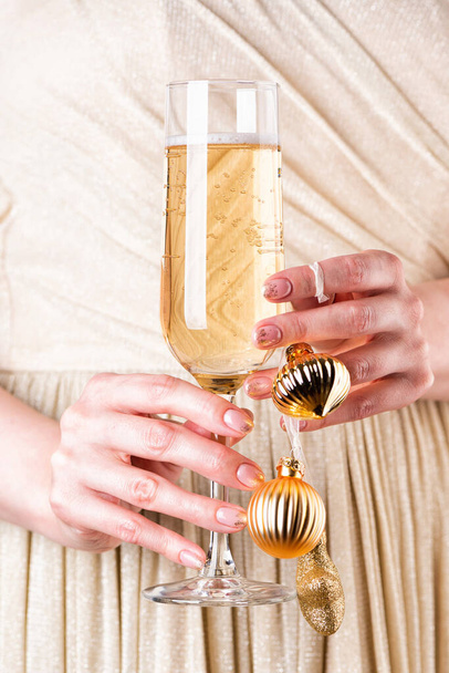 Руки женщины держат бокал шампанского. Идеальный маникюр - Фото, изображение