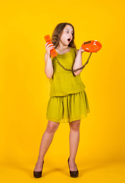 beautiful teen girl with retro phone. kid vintage fashion. happy childhood. cute child on yellow background. new technology in modern life. conversation and communication - Fotografie, Obrázek
