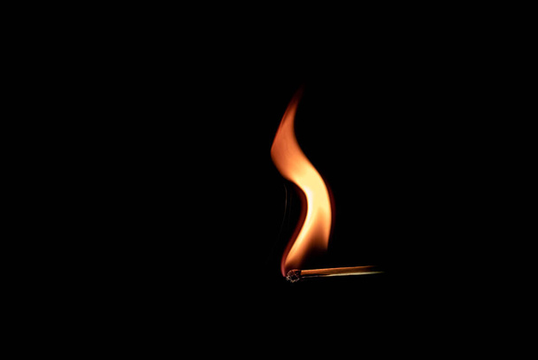 Bastone partita singola bruciando una fiamma arancione pulita. Isolato su sfondo nero. . Foto di alta qualità - Foto, immagini