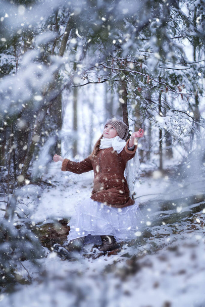 Zamazana nastolatka spacerująca w zimowym śnieżnym lesie. Wysokiej jakości zdjęcie - Zdjęcie, obraz